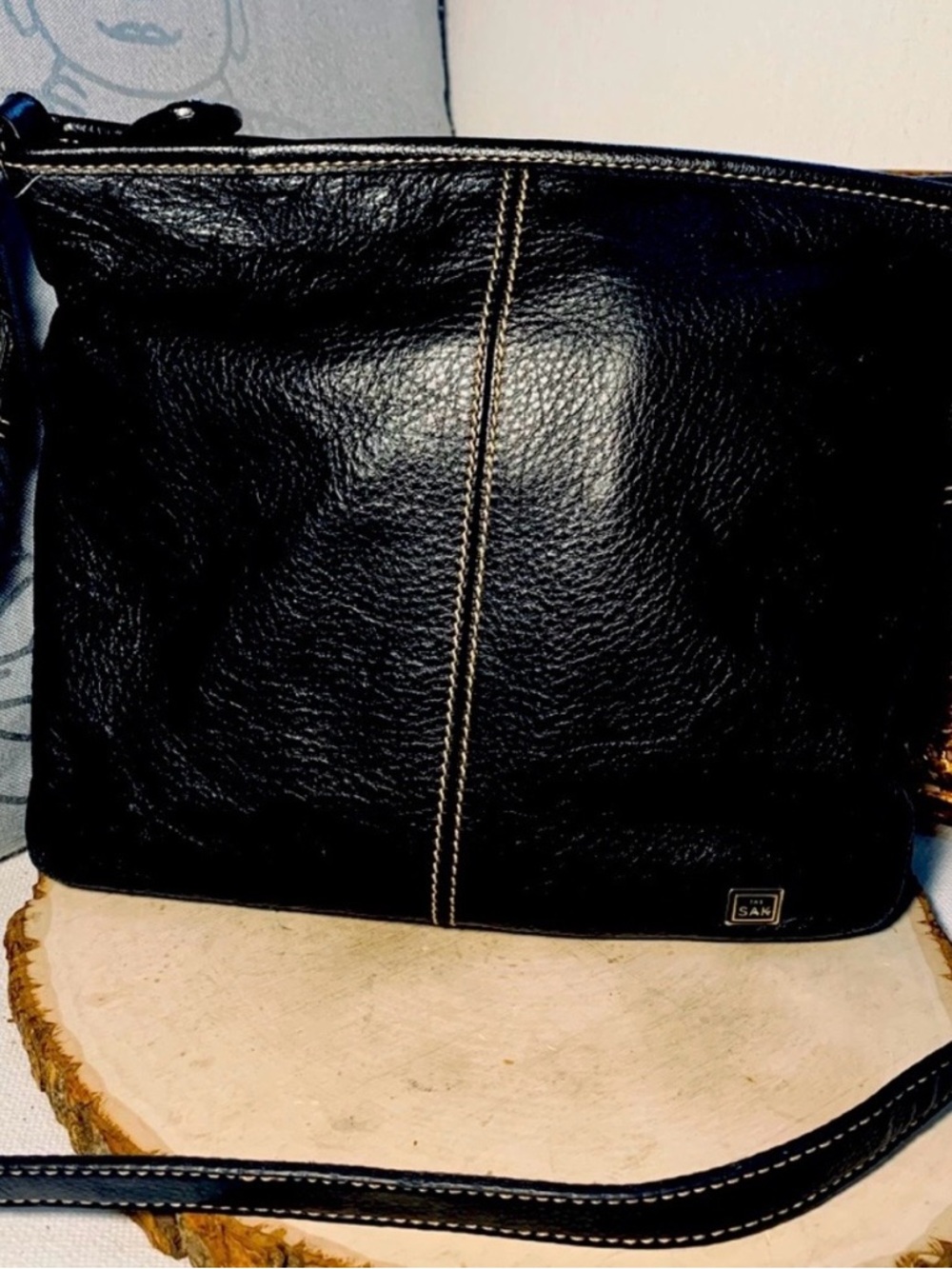 The Sak black crossbody bag with turquoise logo patch